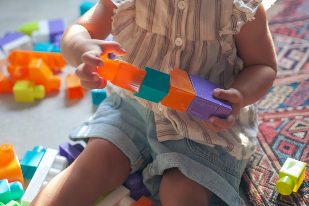 Niño jugando con bloques de colores, aprendizaje y concentración